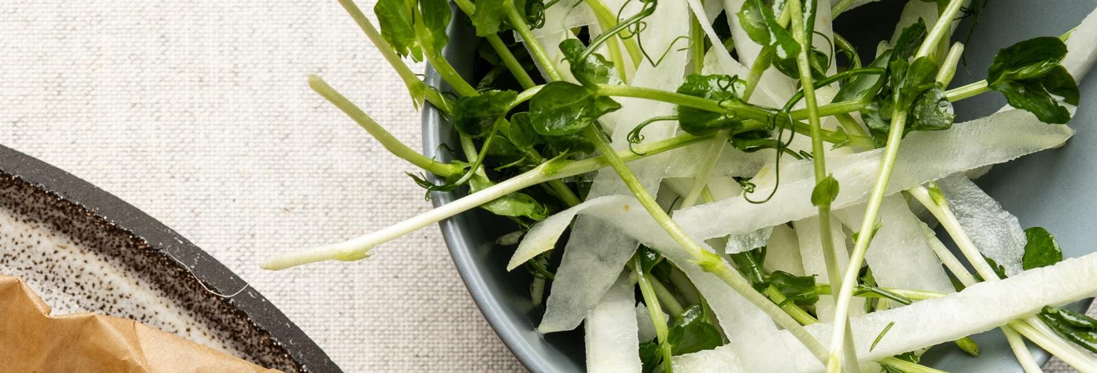 Glaskål med ærteskud og citron