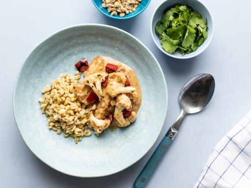 Kylling med blomkål og peberfrugt i jordnøddesauce med koriander og kogte hvedekerner